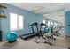 Well-equipped gym with blue walls, carpeted floor, mirror, and exercise equipment at 5809 E Thomas Rd, Scottsdale, AZ 85251