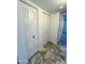 Hallway featuring two white storage closets and tiled flooring, offering ample storage space at 5809 E Thomas Rd, Scottsdale, AZ 85251