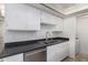 Kitchen showing stainless steel dishwasher and sink with black countertops at 5809 E Thomas Rd, Scottsdale, AZ 85251