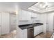 Cozy kitchen features neutral tile, white cabinetry, black countertops, and stainless steel dishwasher at 5809 E Thomas Rd, Scottsdale, AZ 85251