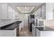 Well-lit kitchen features white cabinets, stainless steel appliances, and tile flooring at 5809 E Thomas Rd, Scottsdale, AZ 85251