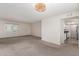 Spacious living room with large window, neutral carpet, decorative light fixture, and kitchen access at 5809 E Thomas Rd, Scottsdale, AZ 85251