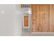 Hallway with wood paneling, tile floor, and a built-in cabinet at the end of the hall at 6808 N 33Rd Ave, Phoenix, AZ 85017