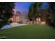 Back yard view of the home, patio furniture, swimming pool, grass, and trees at dusk at 7334 N 7Th Ave, Phoenix, AZ 85021