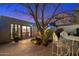 Cozy brick patio with potted plants and outdoor seating adjacent to an open door at twilight at 7334 N 7Th Ave, Phoenix, AZ 85021