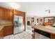 Kitchen with granite countertops, wood cabinets and stainless steel refrigerator, open to the dining and living spaces at 7334 N 7Th Ave, Phoenix, AZ 85021