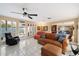 Open-concept living room with tile floors, a ceiling fan, and sliding door access to a covered patio at 7334 N 7Th Ave, Phoenix, AZ 85021