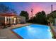 Captivating pool area with poolside seating, lighting and lush greenery, perfect for evening relaxation at 7334 N 7Th Ave, Phoenix, AZ 85021