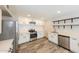 Modern kitchen with white cabinets, stainless steel appliances, and wood-look flooring at 7559 W Turquoise Ave, Peoria, AZ 85345