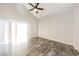 Bright living room featuring vaulted ceiling, modern ceiling fan, and wood-look floors at 7559 W Turquoise Ave, Peoria, AZ 85345