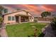 Backyard with grass, covered patio, and beautiful sunset at 7635 E Pampa Ave, Mesa, AZ 85212