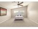 Well-lit primary bedroom featuring a fan, carpet and a window view at 7635 E Pampa Ave, Mesa, AZ 85212