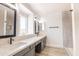 Double vanity bathroom featuring quartz counters, dual mirrors, and modern fixtures at 8567 N 107Th Dr, Peoria, AZ 85345