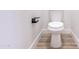 Close-up of toilet with black shelving on light-colored vinyl floor at 8567 N 107Th Dr, Peoria, AZ 85345