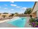 Backyard swimming pool with a black metal fence, desert landscaping and a clear blue sky at 860 E Cierra Cir, San Tan Valley, AZ 85143