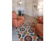 Comfortable seating area with an orange sofa and chair, with access to the dining area at 8649 E Royal Palm Rd # 213, Scottsdale, AZ 85258