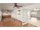 Spacious living room featuring wood floors, ceiling fan, and built in shelving at 10329 W Floriade Dr, Sun City, AZ 85351