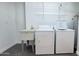 Well-lit laundry room featuring a utility sink, washer, dryer, and wire shelving for storage solutions at 10562 W Campana Dr, Sun City, AZ 85351