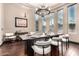 Elegant dining room featuring a modern chandelier, large windows, and stylish decor at 10638 E Hedgehog Pl, Scottsdale, AZ 85262