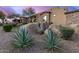 An exterior shot of the home showcasing desert landscaping with large rocks and native plants at 10638 E Hedgehog Pl, Scottsdale, AZ 85262