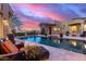 A sparkling pool is surrounded by lounge seating and desert landscaping that compliments the sunset at 10638 E Hedgehog Pl, Scottsdale, AZ 85262