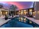 An exterior shot of the rear of the home featuring a pool and stone patios for entertaining at 10638 E Hedgehog Pl, Scottsdale, AZ 85262