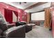 Home theater room with plush leather recliners, large screen, and dramatic red walls at 10638 E Hedgehog Pl, Scottsdale, AZ 85262