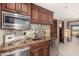Elegant wet bar featuring custom cabinetry, granite countertops, stainless steel appliances, and decorative tile backsplash at 10638 E Hedgehog Pl, Scottsdale, AZ 85262