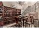 Charming wine cellar with a large wine rack, tasting table, and decorative ironwork staircase at 10638 E Hedgehog Pl, Scottsdale, AZ 85262