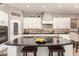 Kitchen island with granite countertops and leather stools provides ample seating, complemented by white cabinetry and appliances at 1152 W Horseshoe Ave, Gilbert, AZ 85233