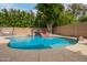 Backyard pool featuring a rock waterfall and slide, with lush landscaping and a swing in a private backyard at 1152 W Horseshoe Ave, Gilbert, AZ 85233