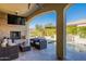 Covered patio with a fireplace, comfortable seating, and a view of the pool with waterfall at 1488 E Sweet Citrus Dr, Queen Creek, AZ 85140