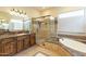 Bright bathroom featuring a soaking tub, glass shower, marble countertops, and a double vanity sink at 1488 E Sweet Citrus Dr, Queen Creek, AZ 85140