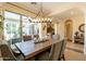Elegant dining room with a wooden table, seating for six, and sliding glass doors to a private patio at 1488 E Sweet Citrus Dr, Queen Creek, AZ 85140