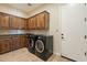 Functional laundry room featuring built-in cabinets, modern appliances, and a convenient door to the exterior at 1488 E Sweet Citrus Dr, Queen Creek, AZ 85140