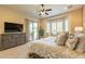 Cozy main bedroom with a bay window, TV, ceiling fan and sliding door access to the patio at 1488 E Sweet Citrus Dr, Queen Creek, AZ 85140