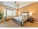 Comfortable main bedroom featuring a bay window, a ceiling fan, and neutral decor at 1488 E Sweet Citrus Dr, Queen Creek, AZ 85140