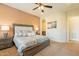 Warm main bedroom features a ceiling fan, a king bed with bedside tables and lamps at 1488 E Sweet Citrus Dr, Queen Creek, AZ 85140