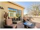 Inviting patio features comfortable chairs, a modern fire pit, and an outdoor grill for entertaining at 1488 E Sweet Citrus Dr, Queen Creek, AZ 85140