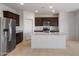 Modern kitchen boasts stainless steel appliances, a center island with sink, and dark wood cabinetry at 16505 N Comet Trl, Maricopa, AZ 85138