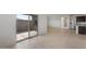 Open living space with tile flooring, sliding glass door to backyard, and view of kitchen appliances at 16505 N Comet Trl, Maricopa, AZ 85138