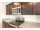 Close up view of the kitchen including granite countertops, stainless steel microwave and glass top electric range at 16575 N Comet Trl, Maricopa, AZ 85138