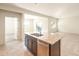 Kitchen island with granite countertops, stainless steel dishwasher, and access to living room and bedroom at 16575 N Comet Trl, Maricopa, AZ 85138