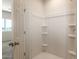 Bathroom view of stand-up shower with built-in shelving and a door to another room at 16575 N Comet Trl, Maricopa, AZ 85138
