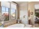 Bright bathroom with a soaking tub, a picturesque window view, and neutral color palette at 17991 N 95Th St, Scottsdale, AZ 85255