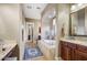 A well-lit bathroom showcasing a soaking tub, dual vanities, and a decorative rug on tile floors at 17991 N 95Th St, Scottsdale, AZ 85255