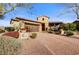 Charming single-story home with a stone facade, manicured landscaping, and a paver driveway leading to a two-car garage at 17991 N 95Th St, Scottsdale, AZ 85255