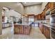 Open-concept kitchen with custom cabinetry, stainless steel appliances, a center island, and seamless flow to the living area at 17991 N 95Th St, Scottsdale, AZ 85255