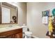 Charming powder room featuring dark wood cabinets, decorative mirror, and subtle design touches at 17991 N 95Th St, Scottsdale, AZ 85255