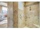 A tiled walk-in shower showcasing updated fixtures and a glass block window for natural light at 17991 N 95Th St, Scottsdale, AZ 85255